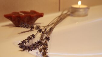 Eine Detailaufnahme einer Trockenblumen-Dekoration mit Kerzen im Badezimmer des Appartement 1 - "Schönleiten" | © Haus Tannenblick