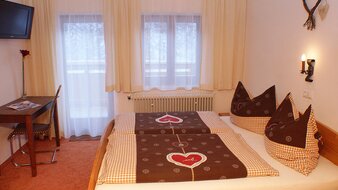 Eine Aufnahme des Doppelbetts mit Blick auf den Balkon im Appartement 1 - "Schönleiten" Schlafzimmer | © Haus Tannenblick