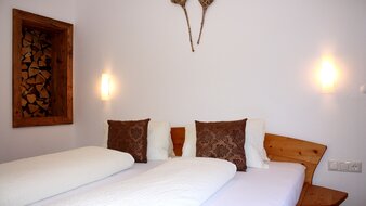 Eine Aufnahme des Doppelbetts in einem Schlafzimmer von Appartement 2 - "Reiterkogel" | © Haus Tannenblick