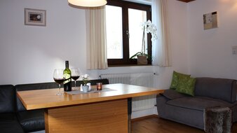 Eine Aufnahme des Esstisches mit Sitzecke im Appartement 2 - "Reiterkogel" Wohnzimmer | © Haus Tannenblick