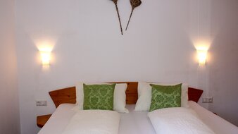 Eine Aufnahme des Doppelbetts in einem Schlafzimmer von Appartement 2 - "Reiterkogel" | © Haus Tannenblick