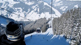 Ein Blick über die Schulter eines Kindes auf eine Skipiste in Saalbach Hinterglemm  | © Haus Tannenblick