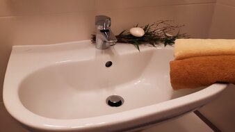 Eine Aufnahme des Waschbeckens mit Handtüchern im Badezimmer des Appartement 3 - "Kohlmais" | © Haus Tannenblick