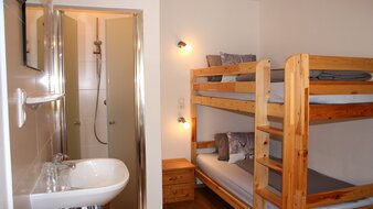 Ein Blick in das Einzelzimmer mit Waschbecken, Dusche und Stockbett | © Haus Tannenblick