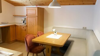 Eine Aufnahme der Küche mit Esstisch und Sitzecke im Appartement 4 - "Schattberg" | © Haus Tannenblick