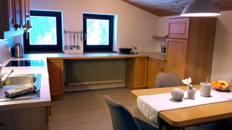Eine Aufnahme der voll ausgestatteten Küche mit Esstisch und Sitzecke im Appartement 4 - "Schattberg" | © Haus Tannenblick