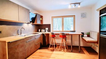 Ein Blick in die Wohnküche mit Esstisch und Sitzecke im Appartement 5 - "Anthony" | © Haus Tannenblick