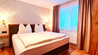 Eine Aufnahme des Doppelbetts im Appartement 5 - "Anthony" Schlafzimmer | © Haus Tannenblick