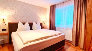 Eine Aufnahme des Doppelbetts im Appartement 5 - "Anthony" Schlafzimmer | © Haus Tannenblick